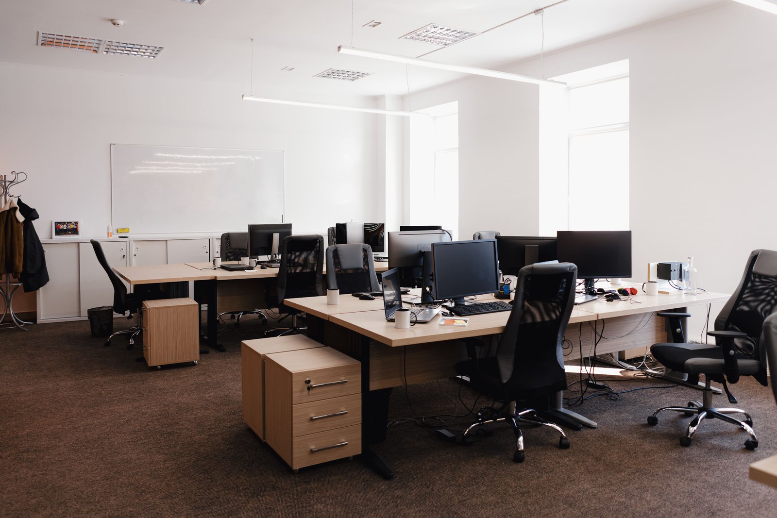Oficina equipada con escritorios, monitores y sillas de trabajo